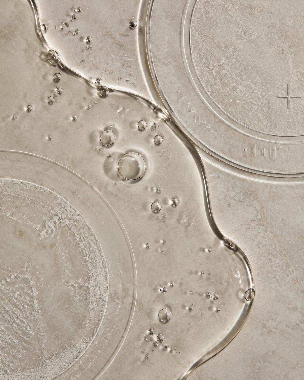 Tiszta folyadék finom laboratóriumi jelekkel üvegfelületen